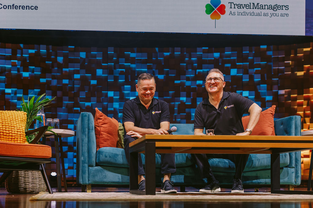 two men seated on a stage