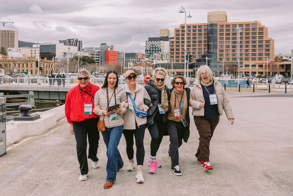 group of women walking with Hobart city in the background