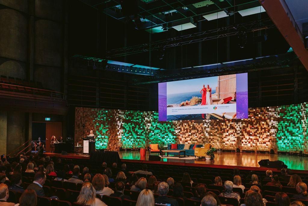 woman on stage presenting at a conference