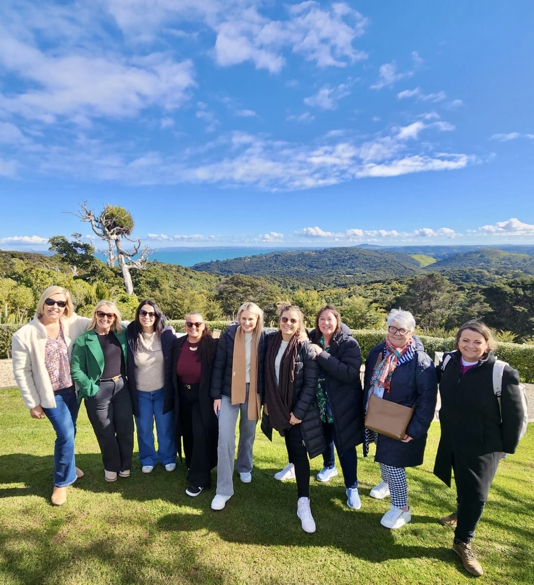 a group of personal travel managers overlooking a NZ landscape